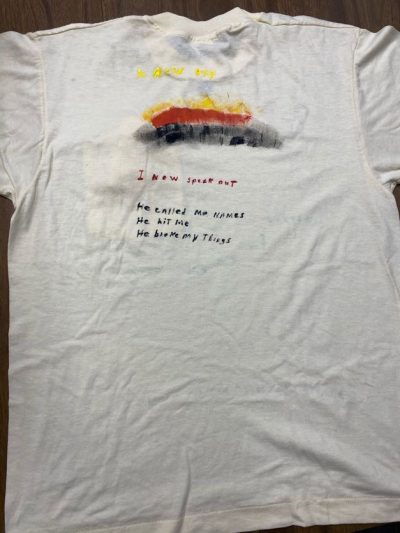 "A new day." "I now speak out." "He called me names. He hit me. He broke my things." White represents people who have died due to violence.