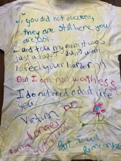 “You did not succeed, they are still here, you are not.” “And told my mom it was just a tap. I didn’t want to feel your harder hit.” “But I am not worthless.” “I do not need a dad like you.” “Victim no longer. I am a survivor. But I will remember.” White represents victims who have died of violence.